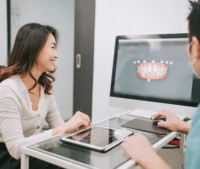 asian chinese male dentist explaining tooth x rays to a patient