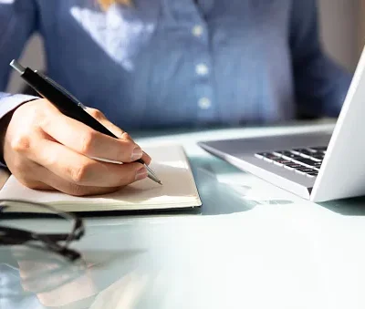 businesswoman writing notes in notebook