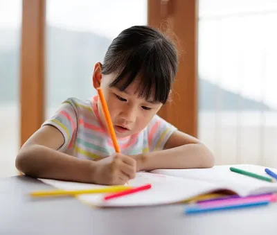 young girl was coloring a coloring book with a pencil at home